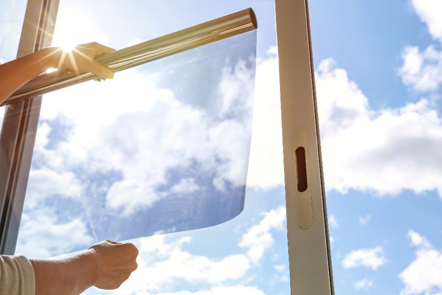 Homeowner applying window film to a residential window