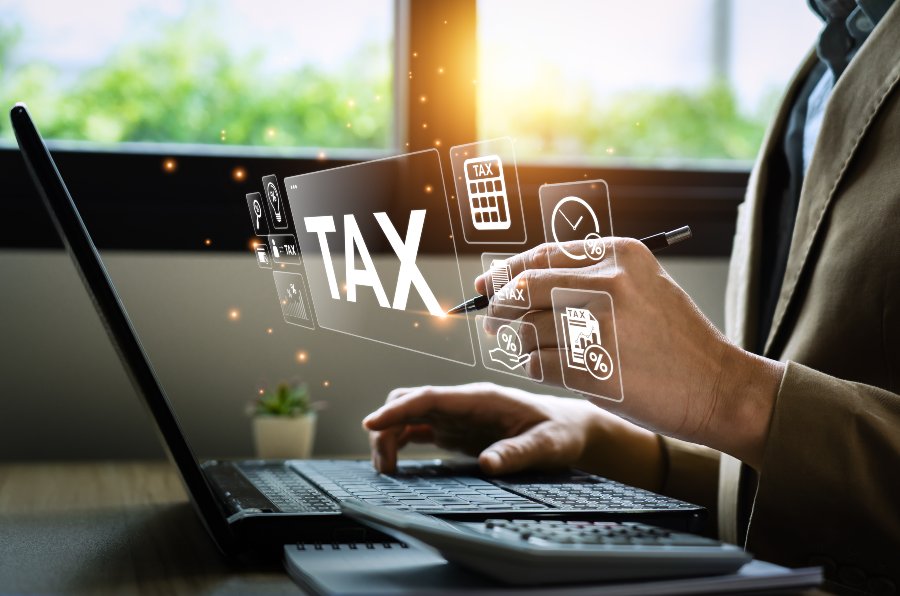 Business professional using a laptop with digital tax icons and tax credit File name: tax-credits